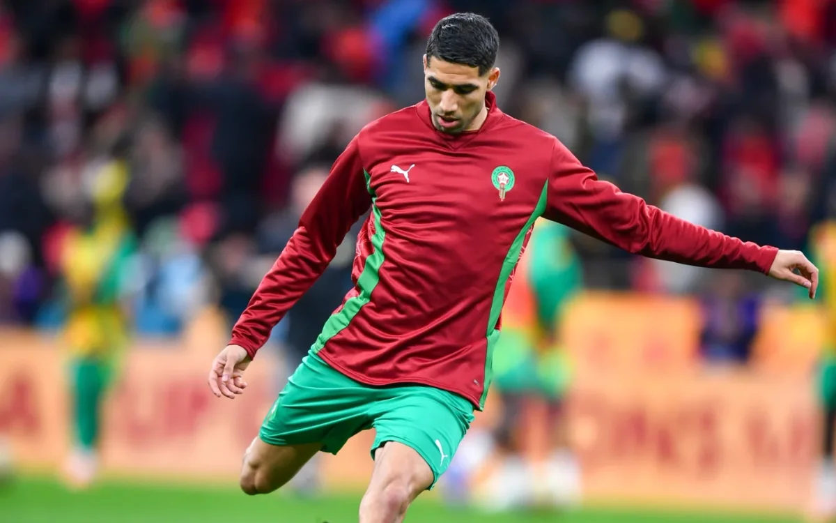 Achraf Hakimi in een rood-groen Marokkaans tenue, warmlopend op het veld tijdens de finale van de Afrika Cup.