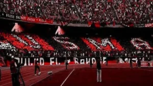 USMA fans displaying vibrant red and black colours in a vibrant stadium atmosphere, showcasing support for their team.