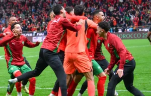 Les joueurs marocains célèbrent ensemble dans leurs tenues vibrantes rouge et vert après une action réussie lors du match contre le Nigeria.