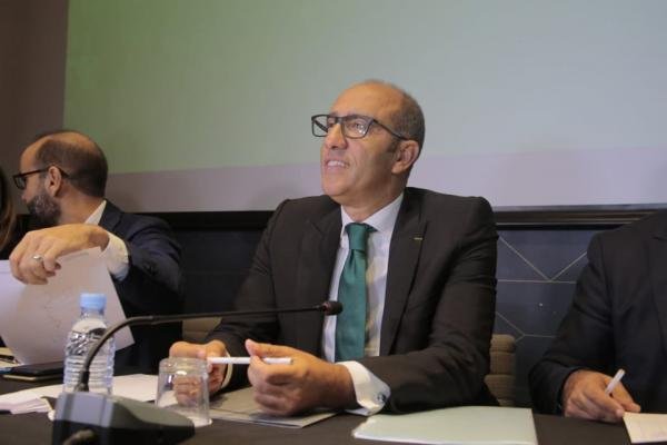 Mouad Ziat, Moroccan football federation official, speaking at a conference, wearing glasses and a suit, with a green tie.